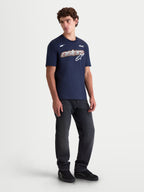 Alpinestars koszulka Cypress CSF, męska koszulka z krótkim rękawem na modelu, granatowa, frontowa grafika Astars Word z siatkowym wypełnieniem, białe i pomarańczowe detale, codzienna odzież sportowa.