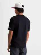Alpinestars P1 CSF Tee, czarna koszulka z krótkim rękawem, odzież sportowa unisex w stylu motorsport, widok z tyłu na modelu, logo Alpinestars Protects na rękawie.
