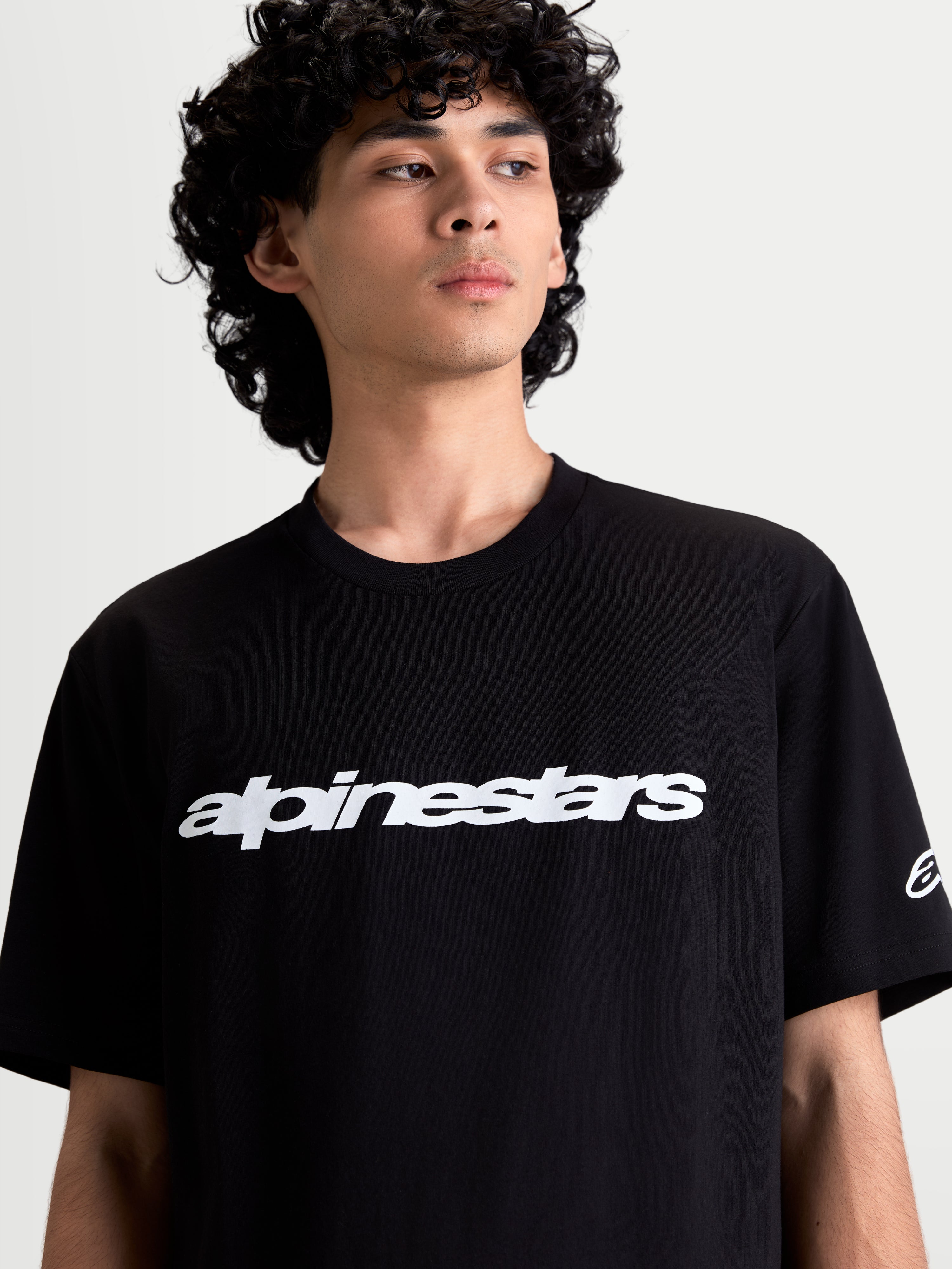 Alpinestars Race Wordmark CSF Tee, On-Model Casual Sportswear T-Shirt, Black and White, featuring a bold front wordmark graphic and sleeve Ageless logo, 60/40 cotton-poly blend for everyday comfort.