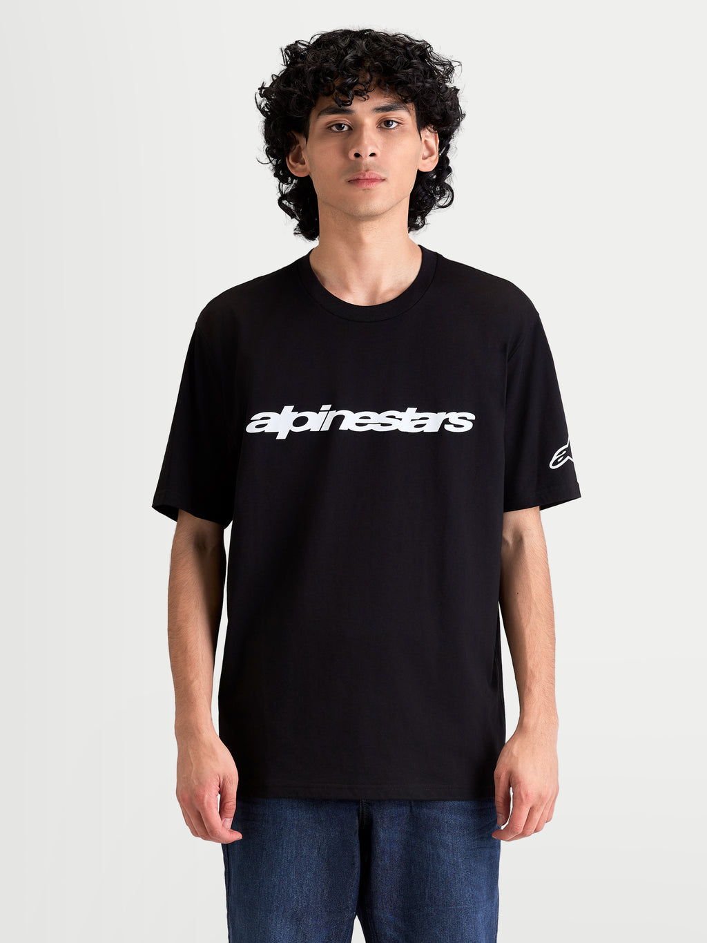 Alpinestars Race Wordmark CSF, męska koszulka z krótkim rękawem na modelu, czarna i biała, wyrazista grafika z logo na przodzie i logo Ageless na rękawie, casualowa odzież sportowa.