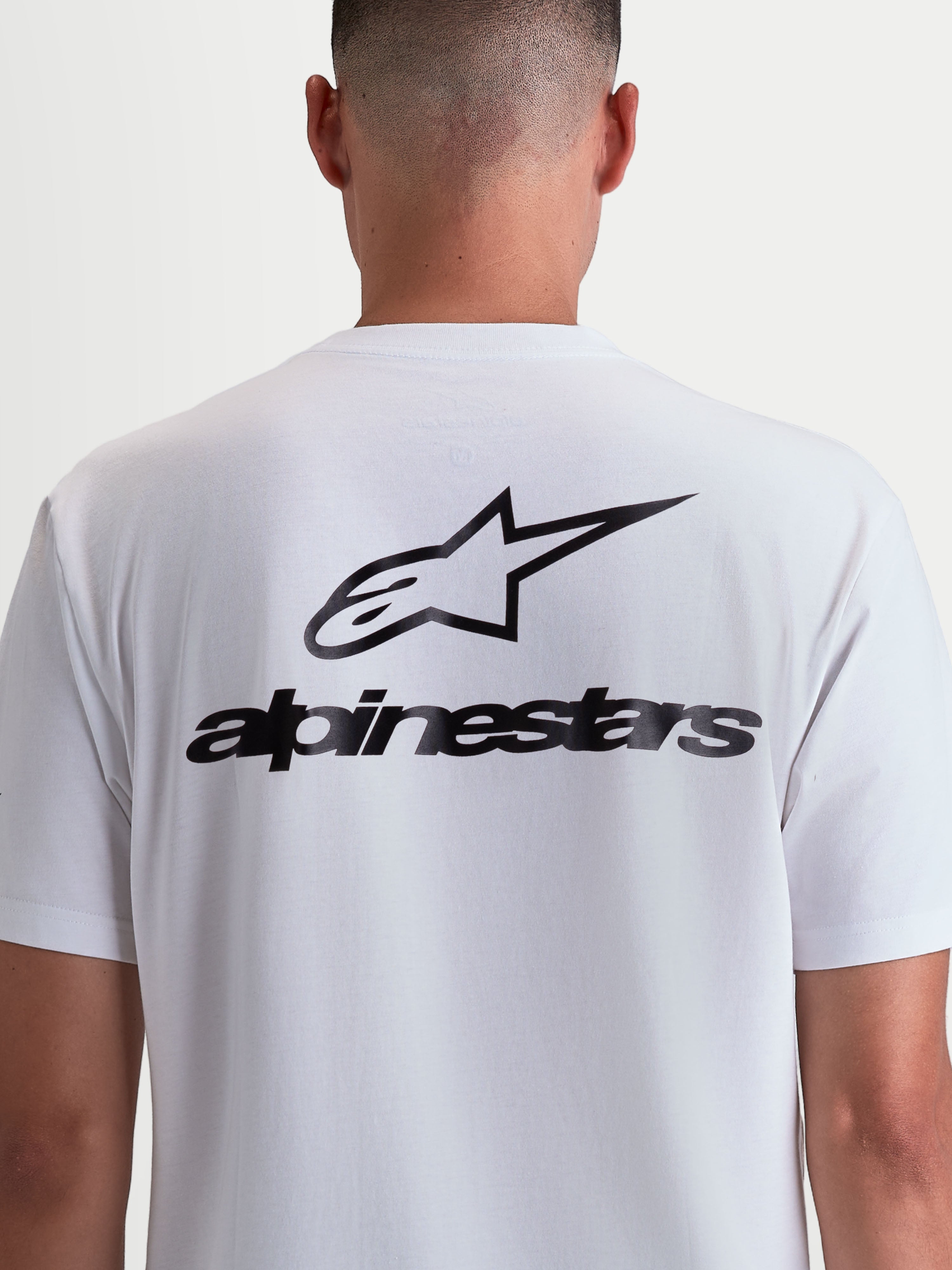 Alpinestars Combo Back CSF Tee, koszulka sportowa z krótkim rękawem, biała i czarna, widok z tyłu na modelu, duża czarna grafika z logo i napisem Alpinestars, mieszanka bawełny i poliestru premium.