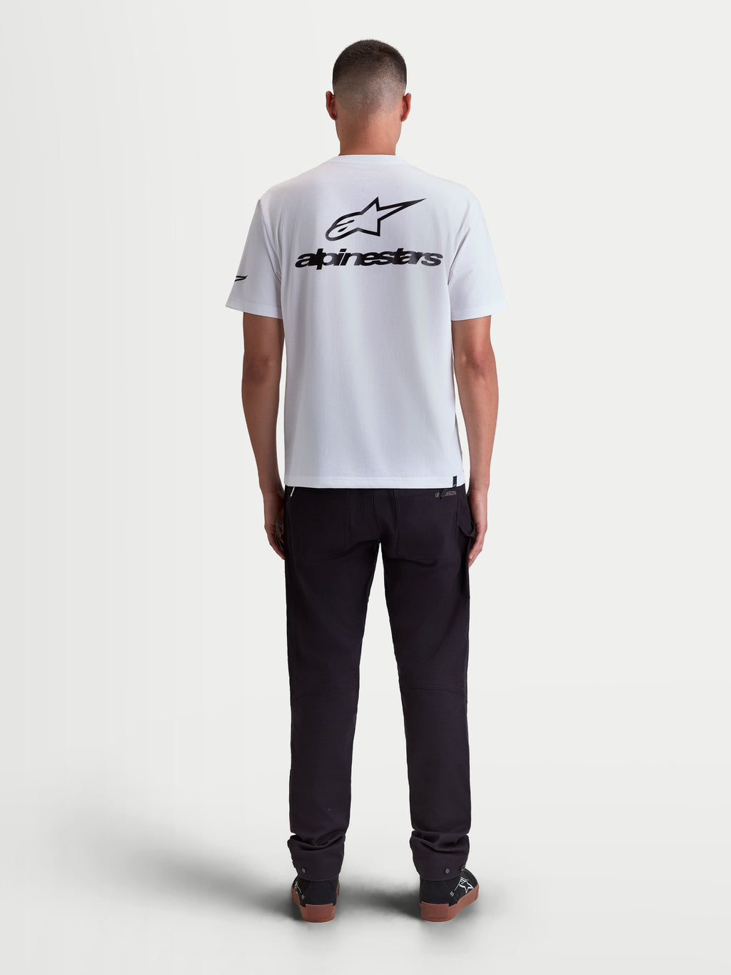 Alpinestars Koszulka Combo Back CSF, biała męska koszulka z krótkim rękawem, duża czarna grafika logo Astars na plecach, widok z tyłu na modelu, mieszanka bawełny i poliestru, odzież sportowa.