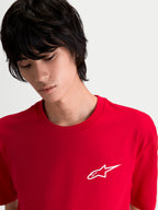Alpinestars Combo Back CSF Tee, czerwona koszulka sportowa z krótkim rękawem na modelu, z małym białym logo Astars na piersi, wykonana z mieszanki bawełny i poliestru premium dla codziennego komfortu.