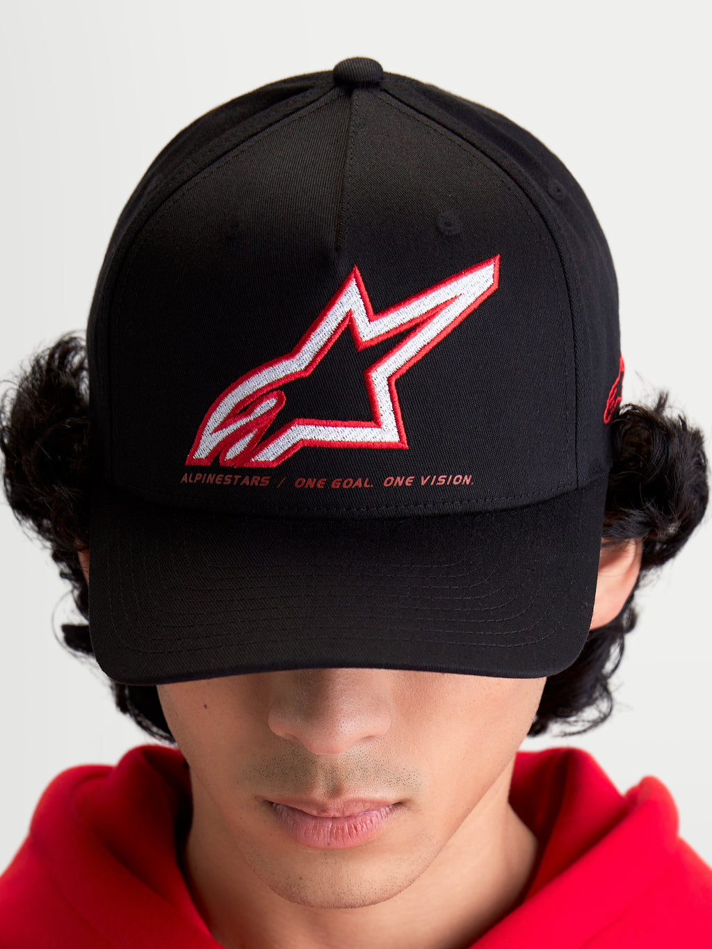 Alpinestars Czapka Lineout, sportowa czapka z daszkiem unisex, czarna, biało-czerwone haftowane logo Astars, hasło One Goal One Vision, zakrzywiony daszek, usztywniona korona, tekstylna konstrukcja, produkt na modelu