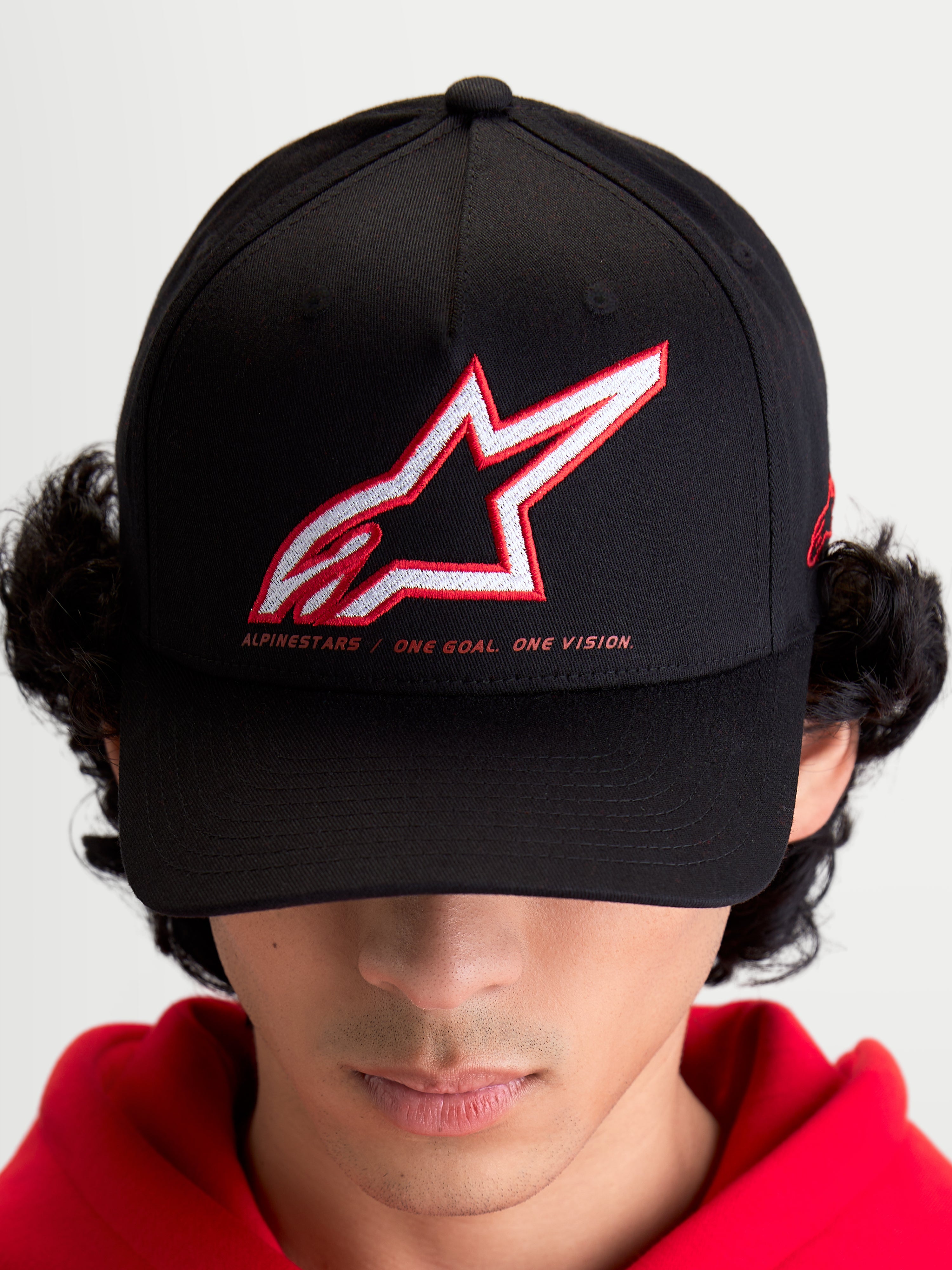 Alpinestars Czapka Lineout, sportowa czapka z daszkiem unisex, czarna, biało-czerwone haftowane logo Astars, hasło One Goal One Vision, zakrzywiony daszek, usztywniona korona, tekstylna konstrukcja, produkt na modelu