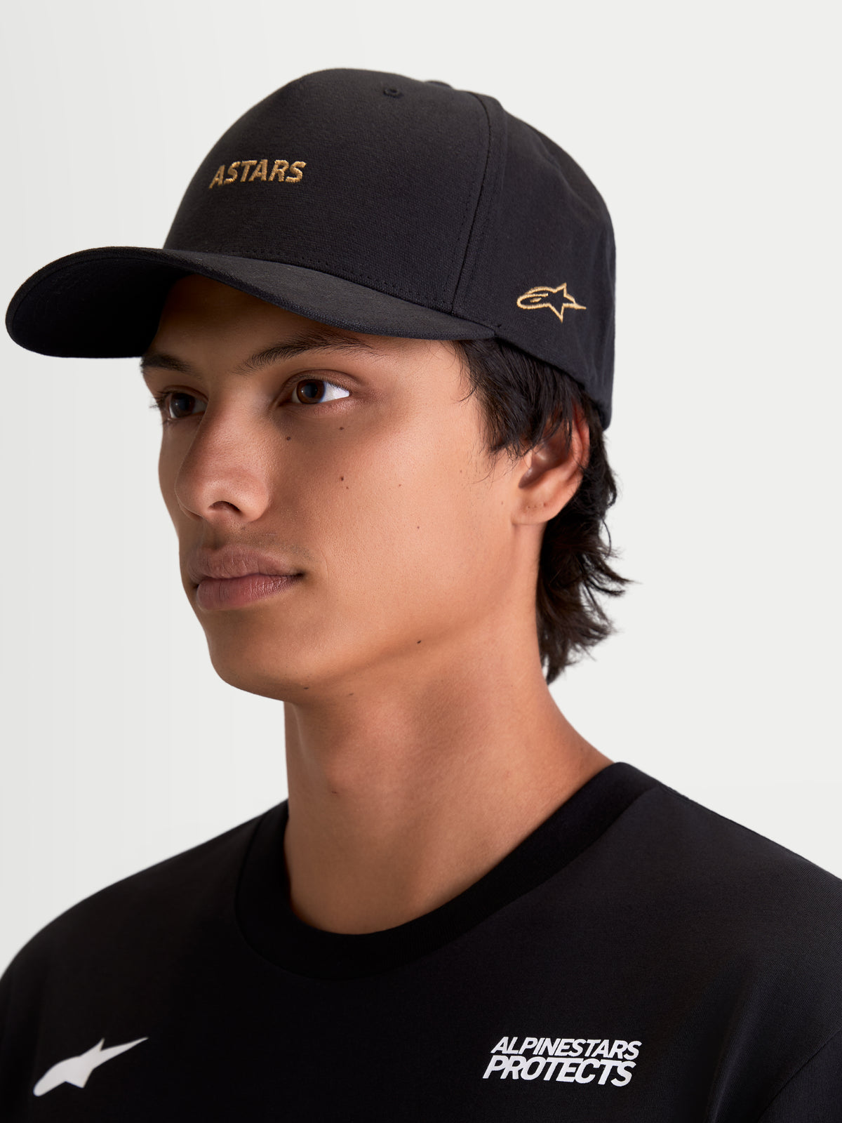 Alpinestars Czapka Z Daszkiem County Canvas, czarna czapka sportswear ze złotym haftowanym logo ASTARS z przodu i z boku, zakrzywiony daszek, usztywniona korona, tkanina oxford peached, codzienna odzież lifestyle inspirowana motorsportem.