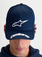 Alpinestars Arclight Hat, czapka z daszkiem sportswear inspirowana motorsportem, dla kobiet i mężczyzn, granatowa i biała, usztywniona korona z teksturowanym logo Astars puff-print, zakrzywiony daszek z logotypem Astars, trwała bawełniana tkanina keprowa, widok z przodu na modelu.