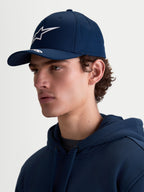 Alpinestars Arclight Hat, granatowa czapka z daszkiem typu sportswear dla kobiet i mężczyzn, z zakrzywionym daszkiem, białym logotypem Astars w technice puff print i usztywnioną koroną. Widok z profilu na modelu prezentuje klasyczny krój inspirowany motorsportem oraz trwałą tkaninę keprową.