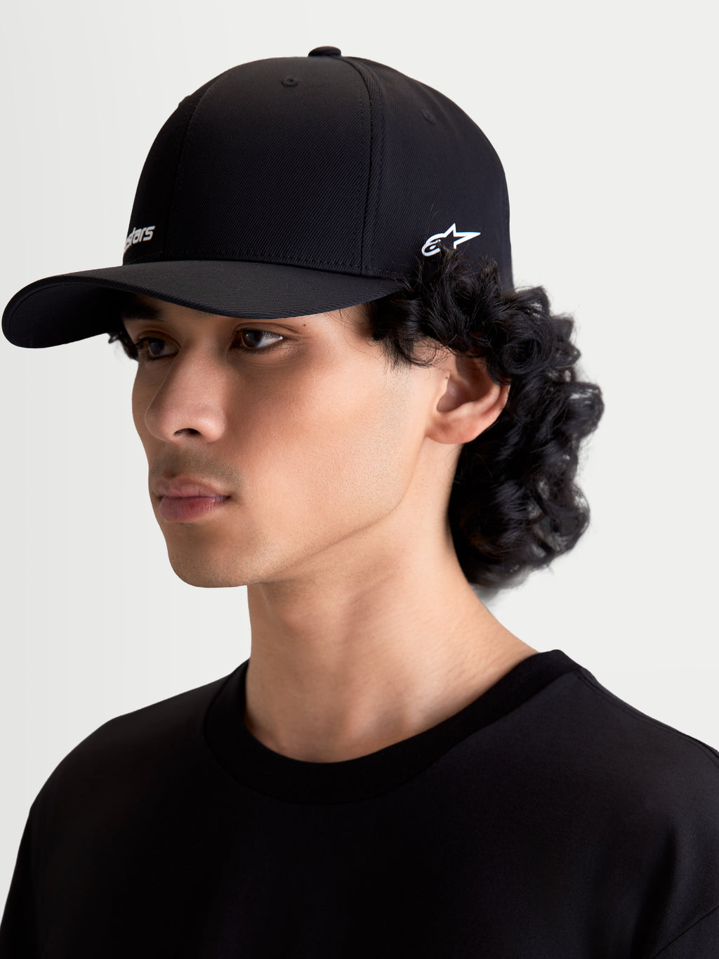 Alpinestars Points Hat, Curved Bill Sportswear Cap, Unisex, Black with White logos, lightweight nylon tactel, flex-back fit, on-model side view, casual motorsport lifestyle headwear.