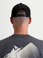 Alpinestars Combo Logo Snapback, czarna czapka z daszkiem, widok z tyłu na modelu pokazujący regulowane zapięcie snapback i mały biały detal logo, wytrzymały bawełniany kepr, odzież sportowa unisex