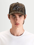 Alpinestars Czapka Z Daszkiem Thicket Realtree, sportowa czapka trucker w kamuflażu i czarnym kolorze, na modelu prezentującym usztywnioną koronę i haftowane logo Astars na przednim panelu