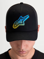 Alpinestars Czapka z daszkiem Meteorite, sportowa czapka z siatkowym tyłem typu trucker, czarna i niebieska, teksturowana naszywka z logo Astars, usztywniona korona i zakrzywiony daszek, noszona przez modela.