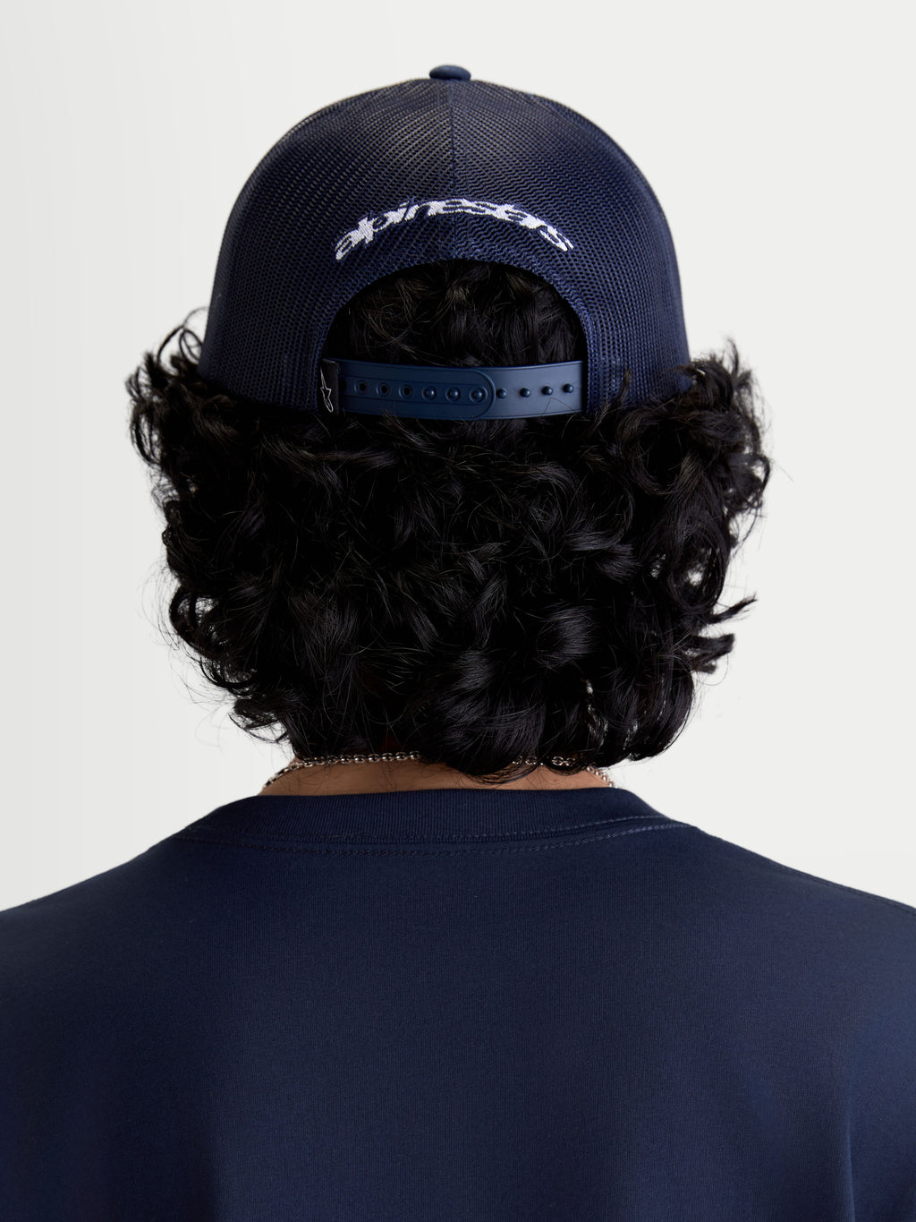 Alpinestars Czapka z daszkiem Meteorite, odzież codzienna sportswear, widok z tyłu na modelu, granatowa, tył z poliestrowej siatki, regulowane zapięcie snapback i białe haftowane logo