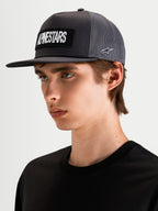 Alpinestars Ten Trucker, czapka z daszkiem sportowa w kolorze ciemnoszarym, na modelu, z haftowanym logo Alpinestars z przodu i logo Astars z boku