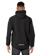 Alpinestars Kascade Rain Jacket, męska kurtka przeciwdeszczowa, czarna, widok z tyłu ukazujący stały kaptur i logo Alpinestars w dolnej części pleców, codzienna wodoodporna odzież sportowa