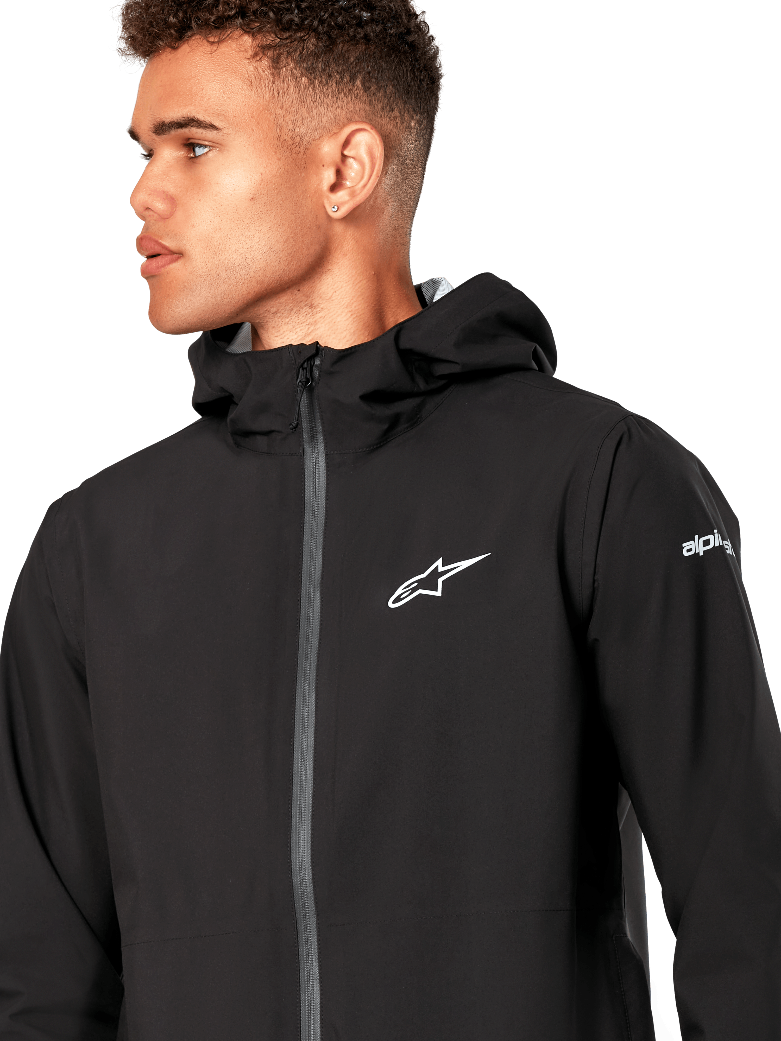 Alpinestars Kascade Rain Jacket, czarna kurtka przeciwdeszczowa typu shell, z białym logo gwiazdy na piersi, stałym kapturem i powlekanym odwróconym zamkiem błyskawicznym z przodu, codzienna odzież wyczynowa inspirowana motorsportem