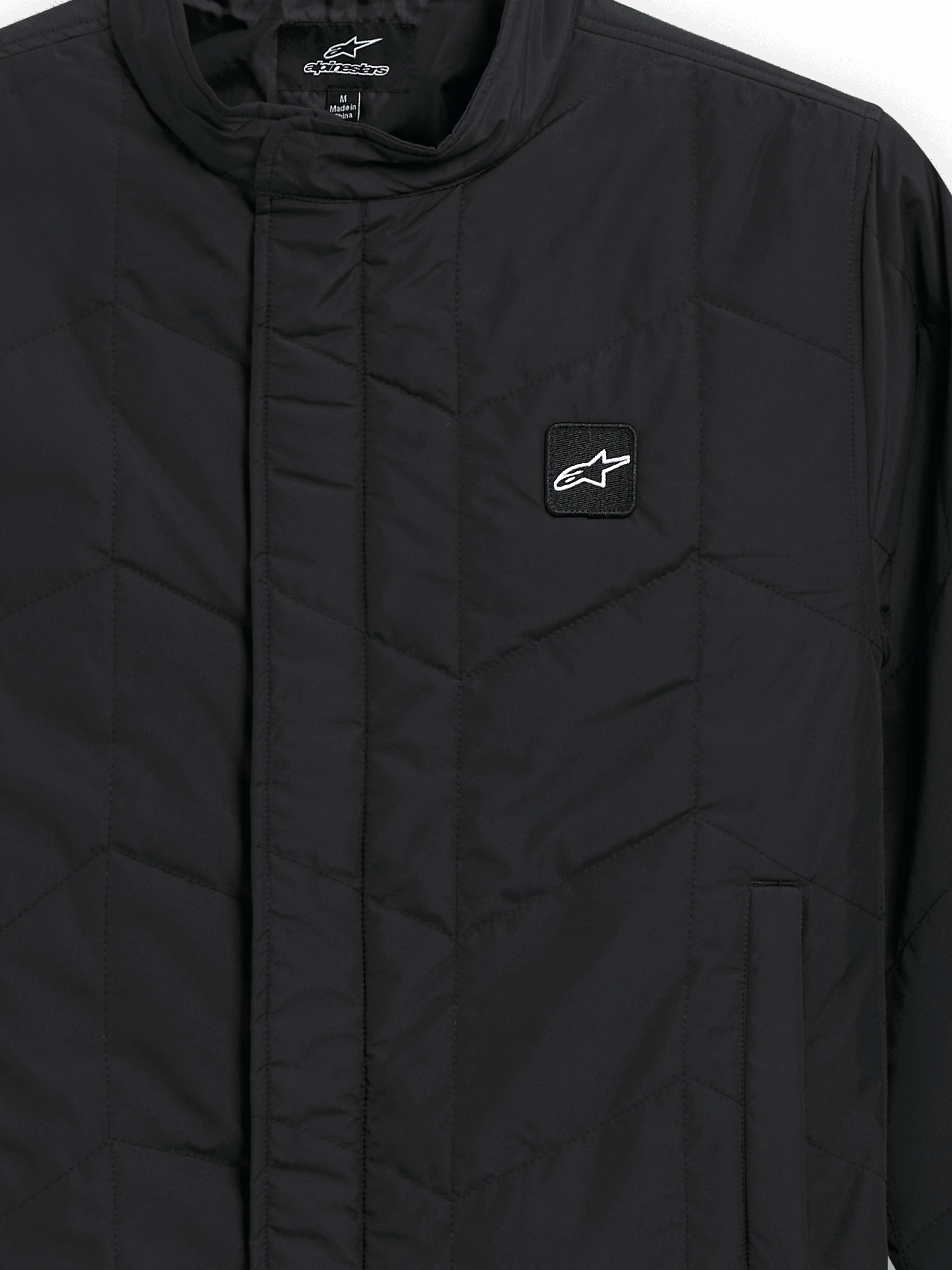 Alpinestars Precedent Jacket, pikowana kurtka sportowa, czarna, zbliżenie na kultowy skośny wzór pikowania, niski kołnierz torowy, zakryty przedni zamek i mała naszywka z logo na piersi