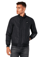 Alpinestars Precedent Jacket, czarna pikowana kurtka ze skośnym wzorem, stylistyka Formuły 1, niski kołnierz torowy, prążkowane mankiety i dół, naszywka z logo na piersi, haft na rękawie, lifestyle'owy streetwear inspirowany sportami motorowymi