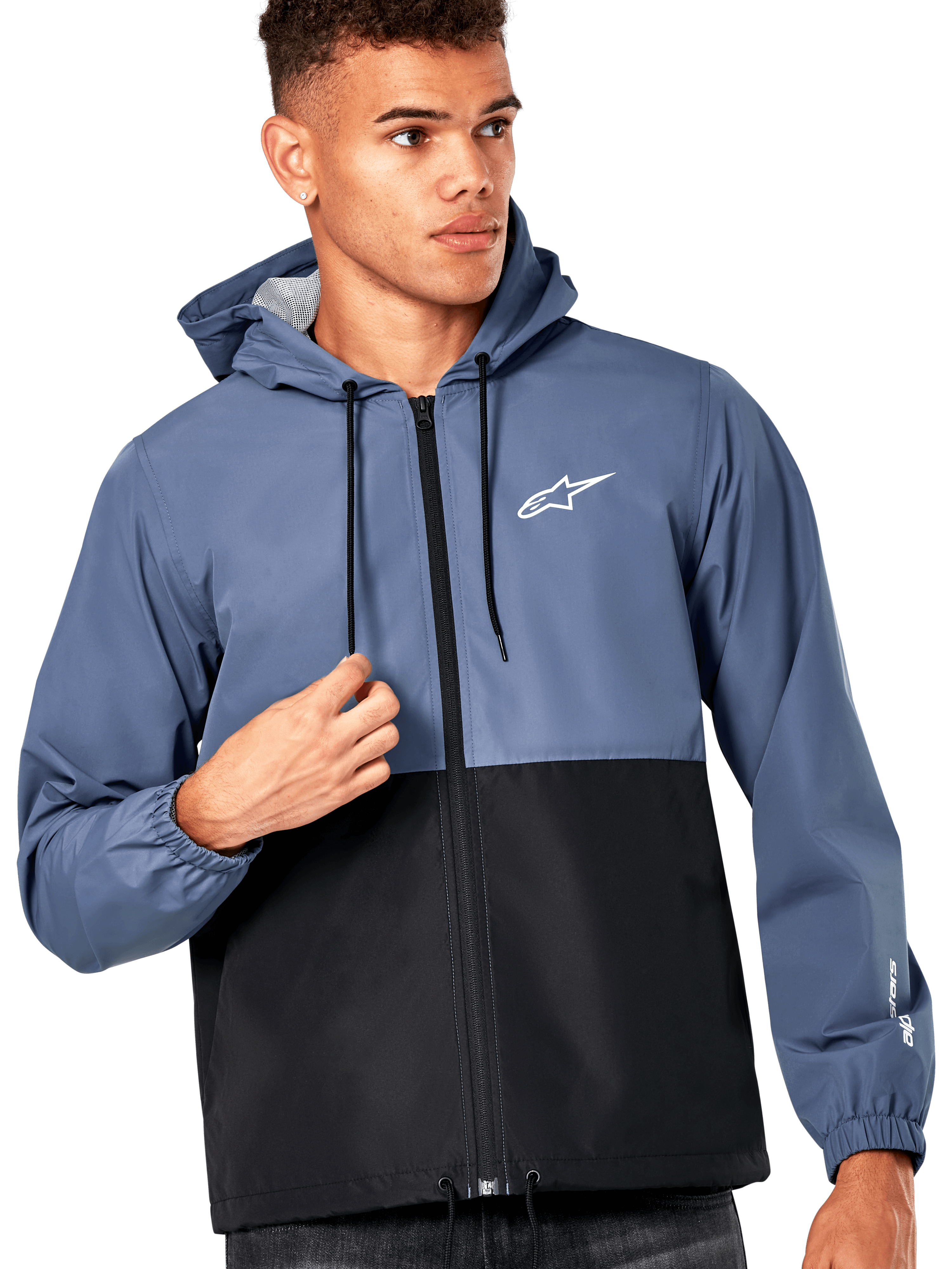 Męski model w kurtce Alpinestars Speeder Windbreaker Jacket, niebiesko-czarny design typu color-block, z kapturem i czarnymi sznurkami, białe logo na piersi, casualowa wiatrówka inspirowana sportami motorowymi