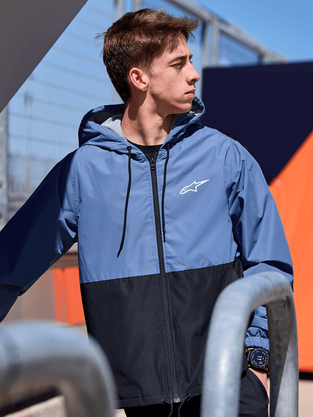 Alpinestars Speeder Windbreaker Jacket, lekka wiatrówka z kapturem, niebiesko-czarna konstrukcja typu color-block, białe logo Alpinestars na klatce piersiowej, podszewka z siatki i kaptur regulowany sznurkiem, casualowy streetwear inspirowany motorsportem
