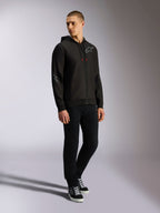 Alpinestars Sessions V3 Hoodie, czarno-szara polarowa bluza z zamkiem z przodu, szare logo na piersi i rękawach, kaptur ze sznurkami o czerwonych końcówkach, widok na całą sylwetkę modela w codziennym stroju streetwearowym inspirowanym motorsportem