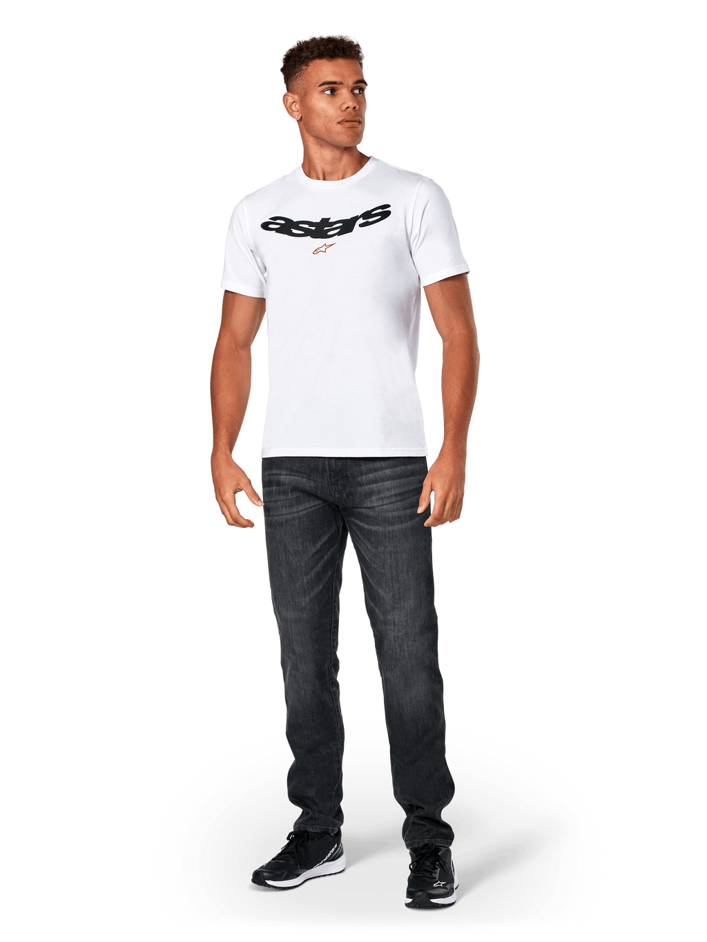 Alpinestars Elliptic CSF Tee, koszulka z krótkim rękawem, biała, czarne łukowate logo Astars z pomarańczowym symbolem gwiazdy, model w czarnych jeansach i sneakersach, codzienna odzież streetwearowa w stylu motorsport