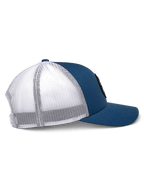 Alpinestars Gambit Trucker Hat, niebiesko-biała, widok z boku, zakrzywiony daszek z usztywnioną koroną, niebieskie przednie panele z kepru i biała siatka poliestrowa z tyłu, codzienne nakrycie głowy inspirowane sportami motorowymi