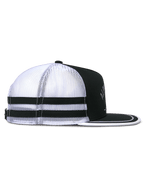 Alpinestars Backline Trucker Hat, widok z boku, czarno-biało-szara, biały siateczkowy tył z dwoma czarnymi poziomymi pasami, usztywniana czarna korona i płaski daszek z białym wykończeniem, codzienna czapka inspirowana motorsportem.