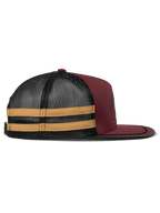 Alpinestars Backline Trucker Hat, kolor ceglasty, czarny i musztardowy, widok z profilu, ciemnoczerwony przód z twillu z tyłem z czarnej siateczki i żółtymi bocznymi paskami, płaski daszek z czarnym wykończeniem sutasz, codzienne nakrycie głowy inspirowane motorsportem