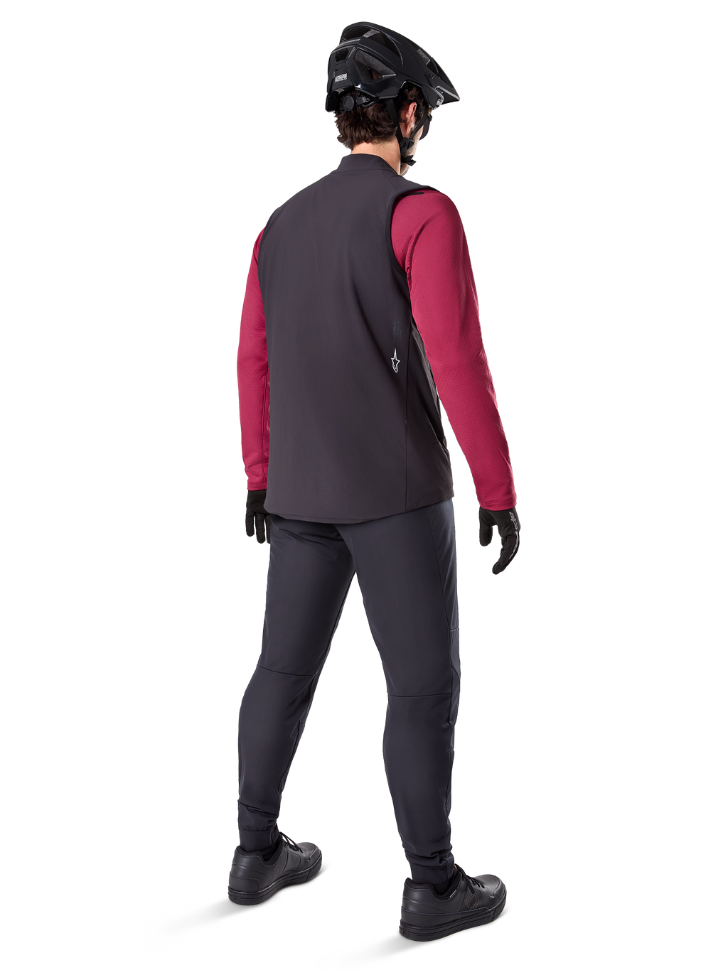 Alpinestars A-Dura Thermal Vest, czarna kamizelka rowerowa, widok z tyłu na modelu ubranym w bordową koszulkę z długim rękawem i czarne spodnie rowerowe, w zestawie z czarnym kaskiem MTB i rękawicami, odzież techniczna do jazdy w chłodne dni