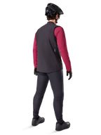Alpinestars A-Dura Thermal Vest, czarna kamizelka rowerowa, widok z tyłu na modelu ubranym w bordową koszulkę z długim rękawem i czarne spodnie rowerowe, w zestawie z czarnym kaskiem MTB i rękawicami, odzież techniczna do jazdy w chłodne dni