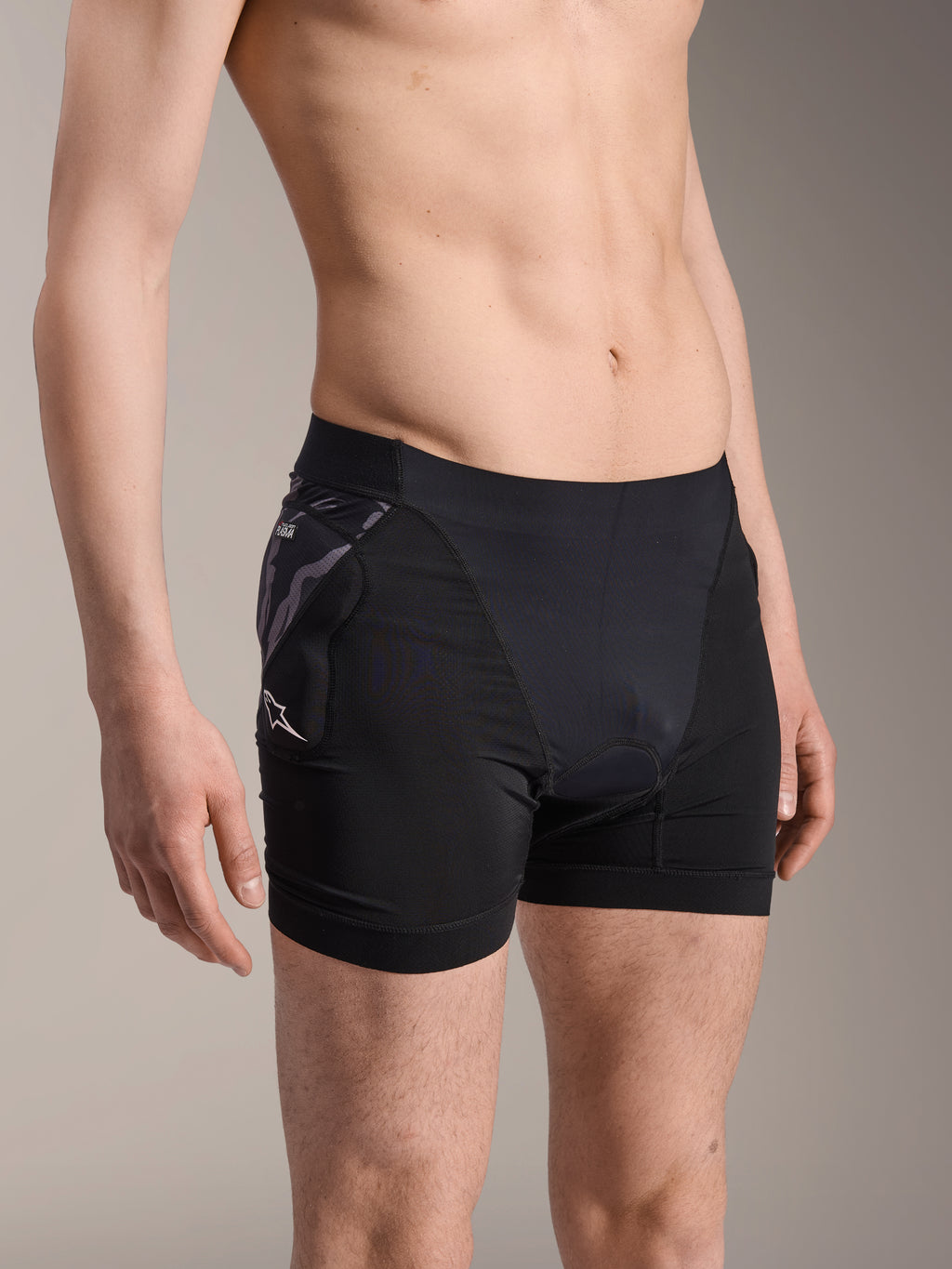 Bokserki ochronne Alpinestars A-Motion Plasma, czarne rowerowe spodenki termoaktywne, ochraniacz bioder z wzorem moro i białym logo Astar, oddychająca tkanina siateczkowa, odzież ochronna do kolarstwa górskiego
