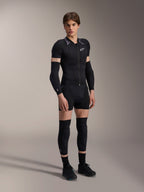 Męski model w Alpinestars A-Motion Plasma Protection Jacket - Short Sleeve, kolor Black Camo z szarymi wzorzystymi ramionami, centralny zamek błyskawiczny z przodu i białe logo na piersi, czarne ochraniacze rąk i kolan, techniczna odzież ochronna MTB do jazdy w terenie