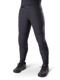 Alpinestars A-Dura Thermal Pant, czarne spodnie rowerowe MTB, noszone z czarnymi butami rowerowymi, z zapięciem na zapadkę w pasie, małym białym logo na udzie, zwężany krój do jazdy w chłodne dni