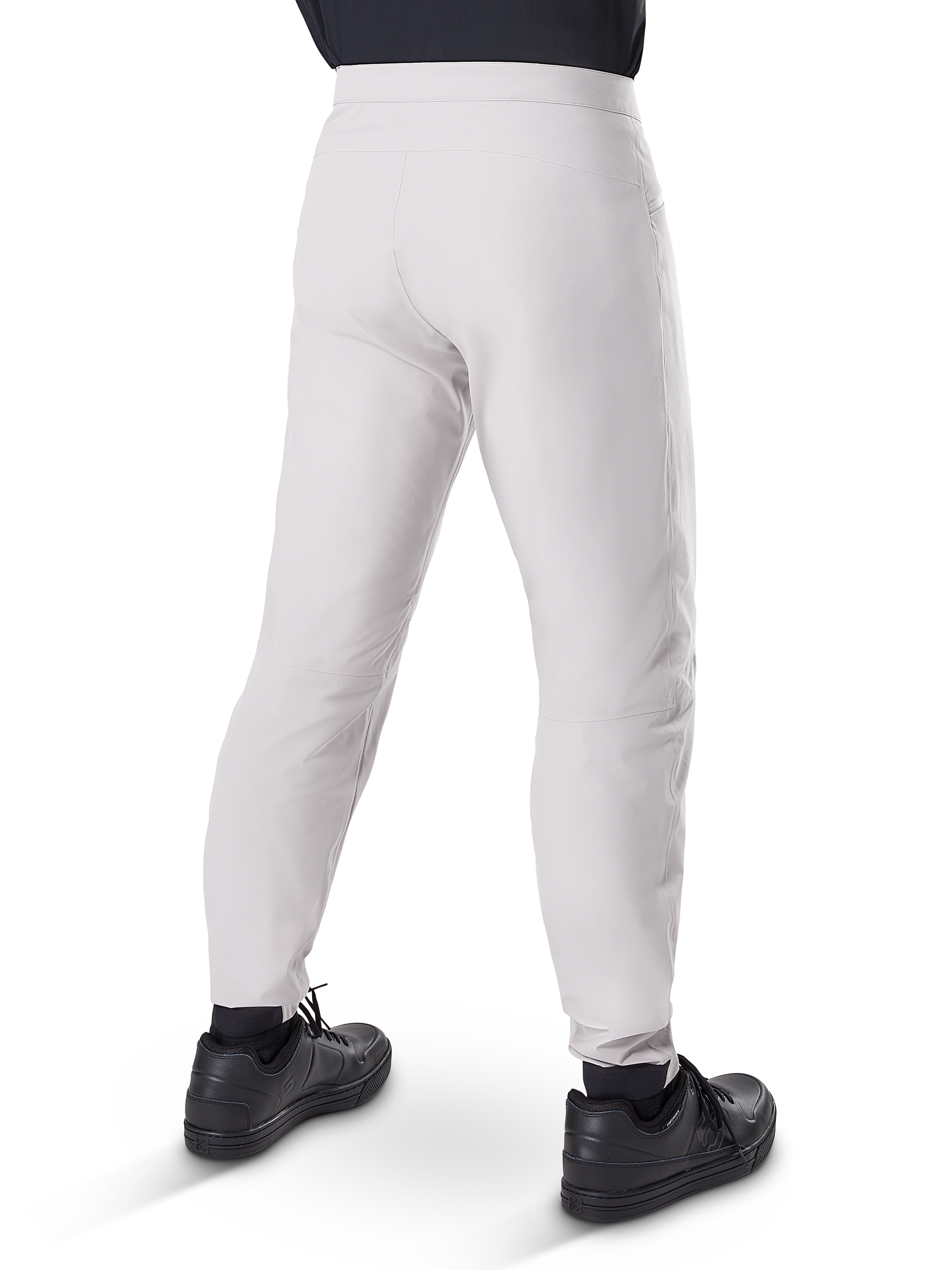 Alpinestars A-Dura Waterproof Pants, spodnie rowerowe MTB, tytanowy szary, widok z tyłu przedstawiający zwężane nogawki i elastyczne mankiety, noszone z czarnymi butami, wodoodporna odzież techniczna do kolarstwa górskiego