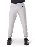 Alpinestars A-Dura Waterproof Pants, spodnie rowerowe MTB, Titanium Gray, widok z przodu, wyposażone w czarne zapięcie na zapadkę w pasie i dwie kieszenie zapinane na zamek, elastyczne mankiety, zestawione z czarnymi sneakersami, techniczna odzież wodoodporna do kolarstwa górskiego