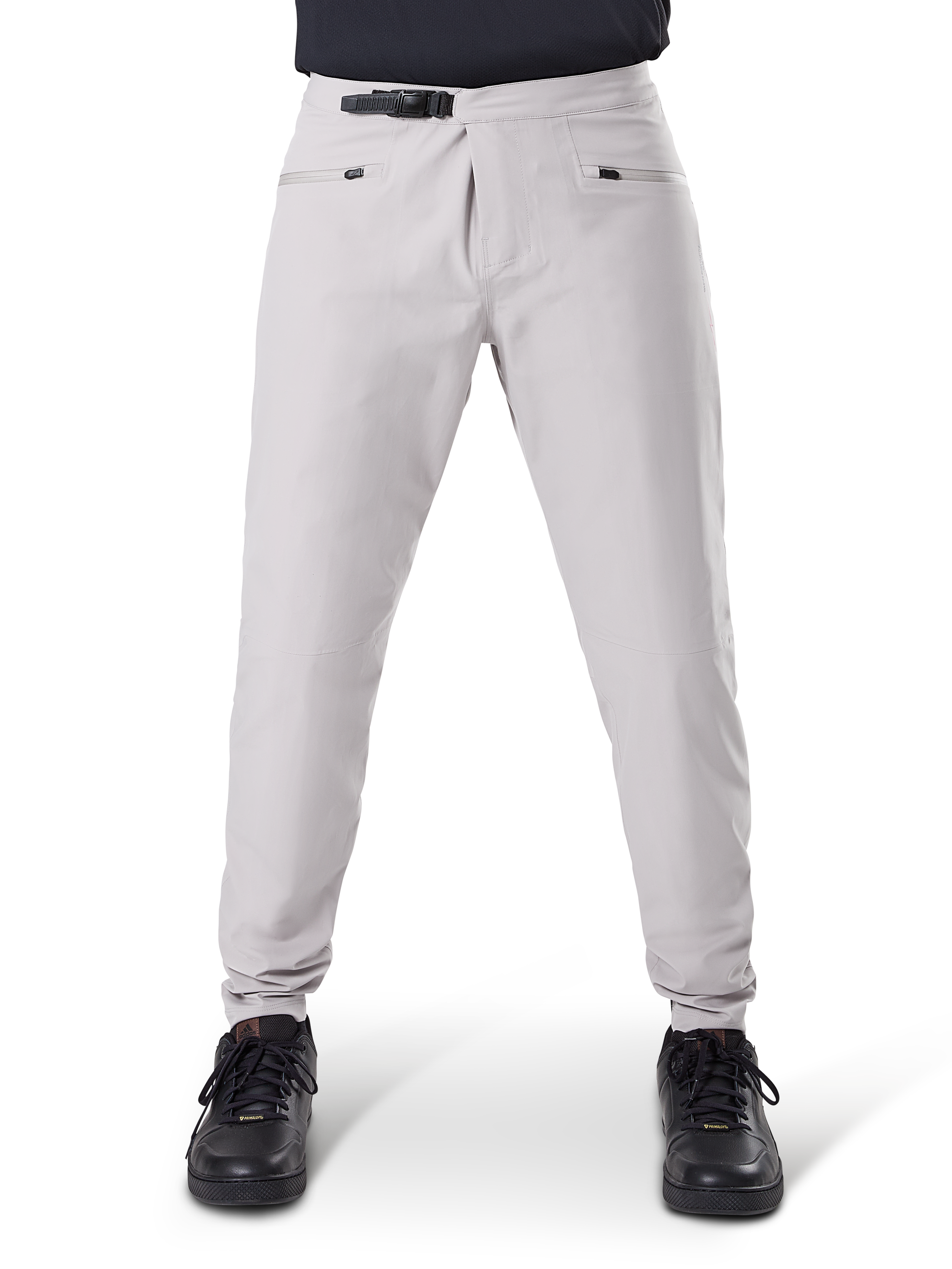 Alpinestars A-Dura Waterproof Pants, spodnie rowerowe MTB, Titanium Gray, widok z przodu, wyposażone w czarne zapięcie na zapadkę w pasie i dwie kieszenie zapinane na zamek, elastyczne mankiety, zestawione z czarnymi sneakersami, techniczna odzież wodoodporna do kolarstwa górskiego