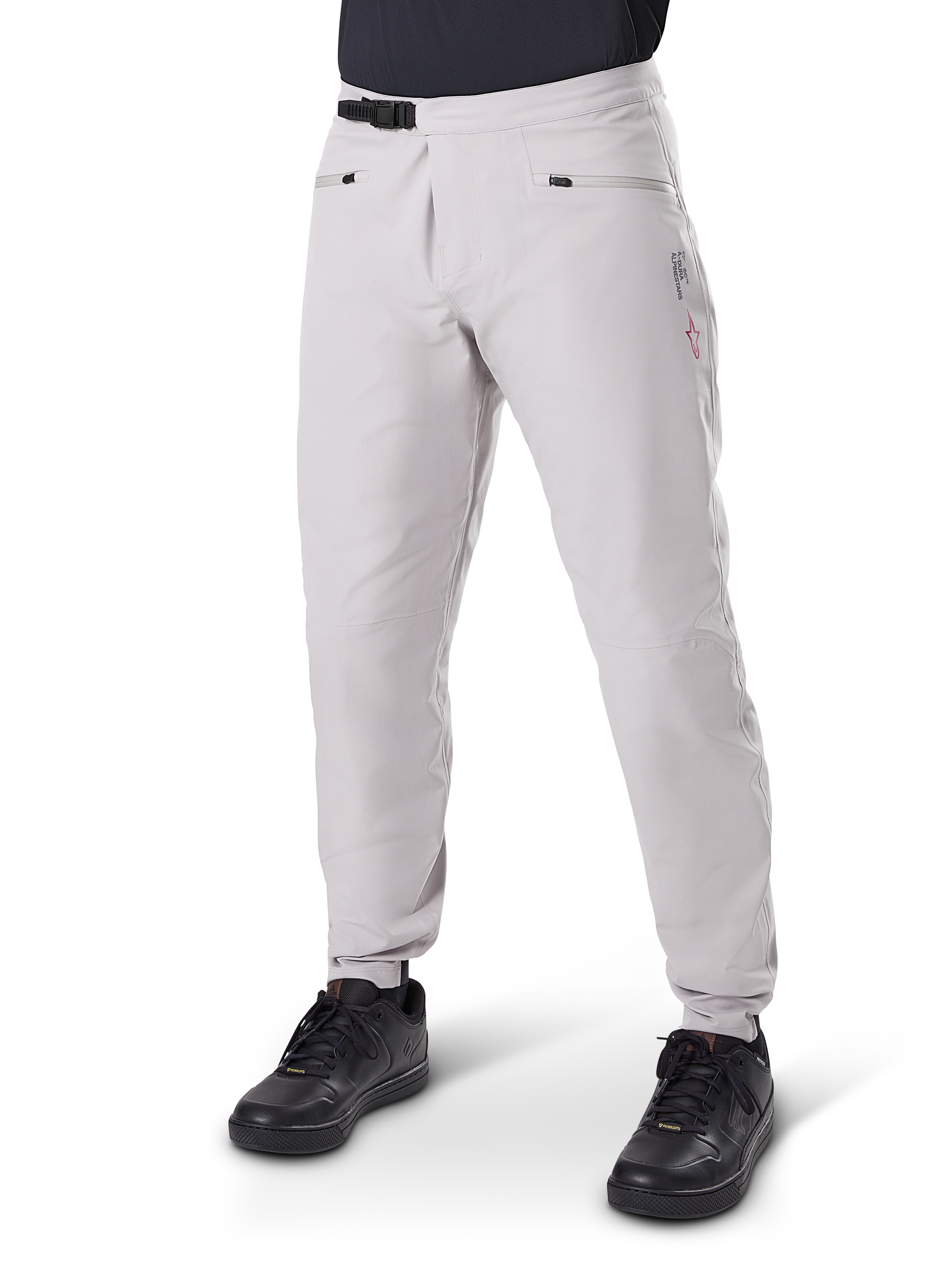 Alpinestars A-Dura Waterproof Pants, spodnie na rower górski, szary tytanowy, z czarnym zapięciem zapadkowym w pasie i kieszeniami na zamek, zwężane nogawki z elastycznymi mankietami, zestawione z czarnymi butami, wytrzymała wodoodporna konstrukcja 3L do jazdy terenowej