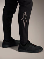 Czarne spodnie MTB A-Supra Elite ze srebrnym logo Astars na dole nogawki, zaprojektowane do wyczynowej jazdy górskiej.