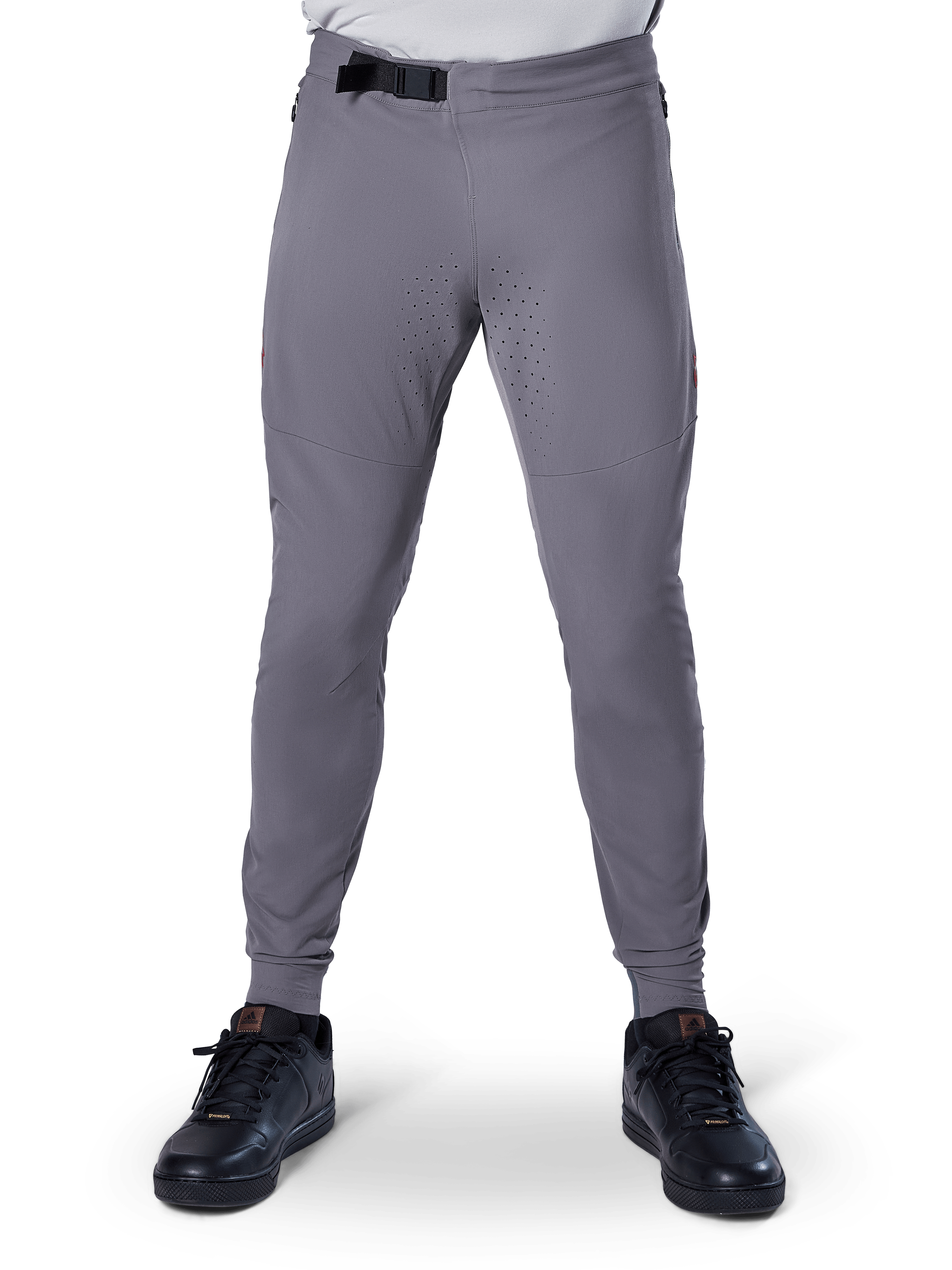 Spodnie Alpinestars A-Aria Elite, spodnie rowerowe MTB, ciemnoszare, z laserowymi perforacjami na wewnętrznej stronie ud dla wentylacji i magnetycznym zapięciem w pasie, sportowy krój ze zwężanymi nogawkami, noszone z czarnymi butami sportowymi