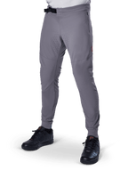 Alpinestars A-Aria Elite Pants, ciemnoszare spodnie MTB, laserowo perforowane panele na udach, czarne magnetyczne zapięcie na klamrę, kieszeń zapinana na zamek, czerwone logo, dopasowany krój performance, noszone z czarnymi butami
