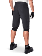 Alpinestars A-Aria Shorts, spodenki rowerowe MTB, czarne, widok z tyłu prezentujący sportowy krój i minimalistyczny design, zestawione z czarnymi rękawiczkami i skarpetami z białym logo Astars, techniczna odzież rowerowa do jazdy w terenie