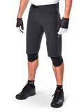 Alpinestars A-Aria Shorts, spodenki do kolarstwa górskiego, czarne, o długości do kolan, z przednimi kieszeniami na zamek i regulowaną klamrą zapadkową w pasie, noszone z czarnymi ochraniaczami na kolana, skarpetami i rękawiczkami rowerowymi