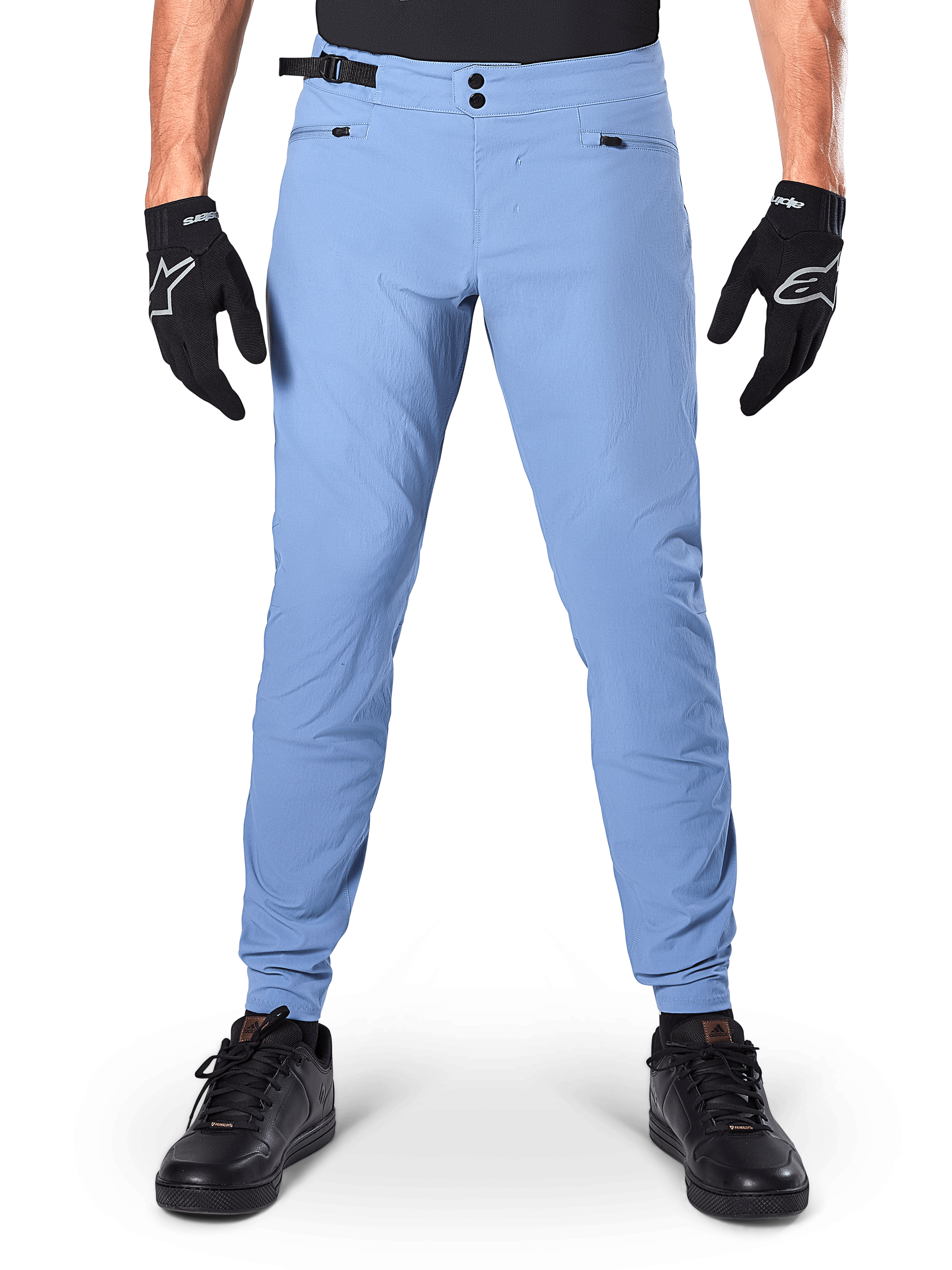 Alpinestars A-Dura Pants, spodnie MTB, Infinity Blue, jasnoniebieskie spodnie rowerowe górskie z podwójnym zapięciem na zatrzaski i kieszeniami na zamek, noszone z czarnymi rękawiczkami i czarnymi butami, regularny krój z elastycznymi mankietami
