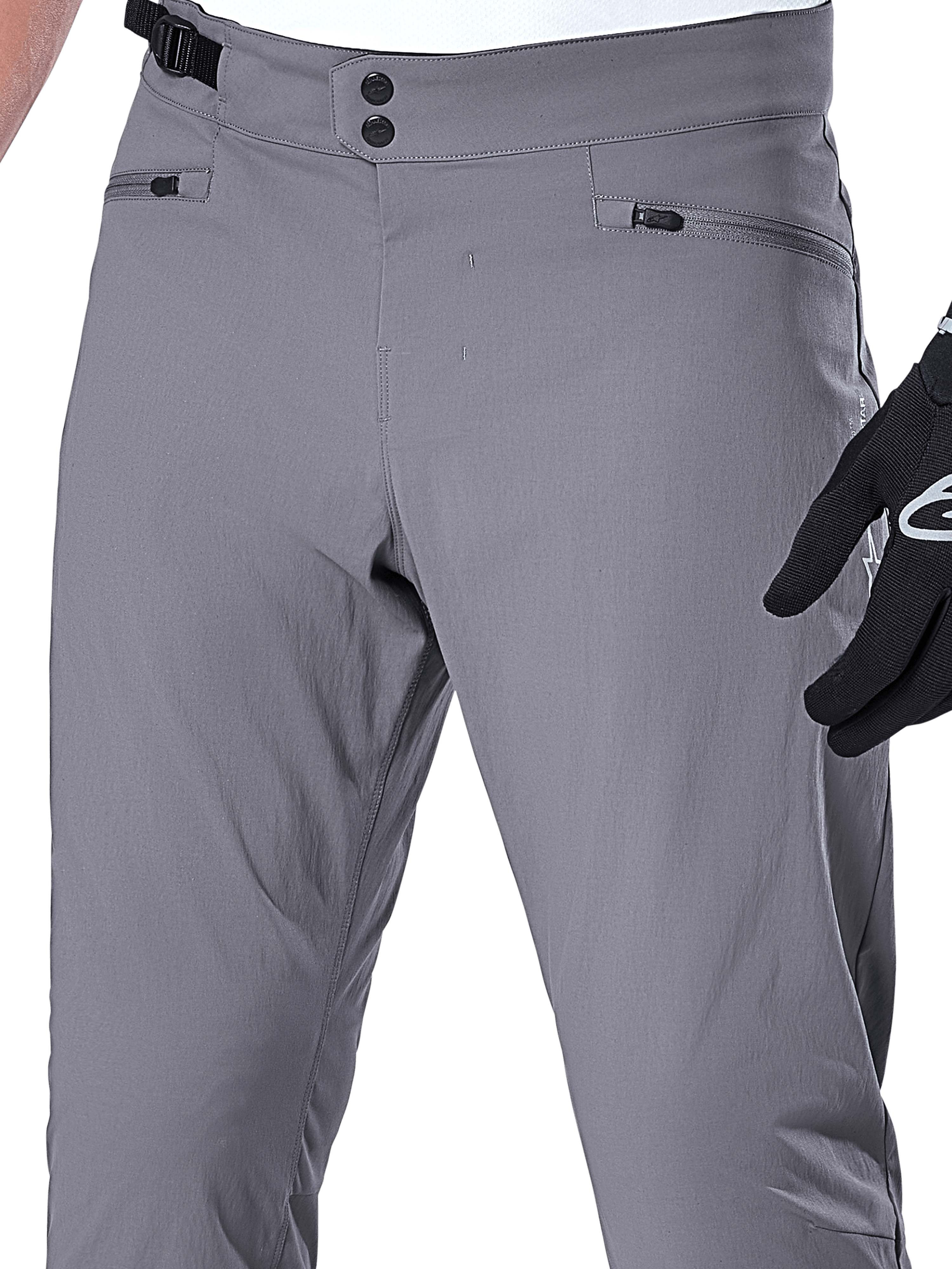 Alpinestars A-Dura Pants, spodnie MTB, ciemnoszare, zbliżenie na obszar talii z podwójnym zapięciem na zatrzaski, boczną regulacją i kieszeniami zapinanymi na zamek, wytrzymały elastyczny materiał do kolarstwa górskiego