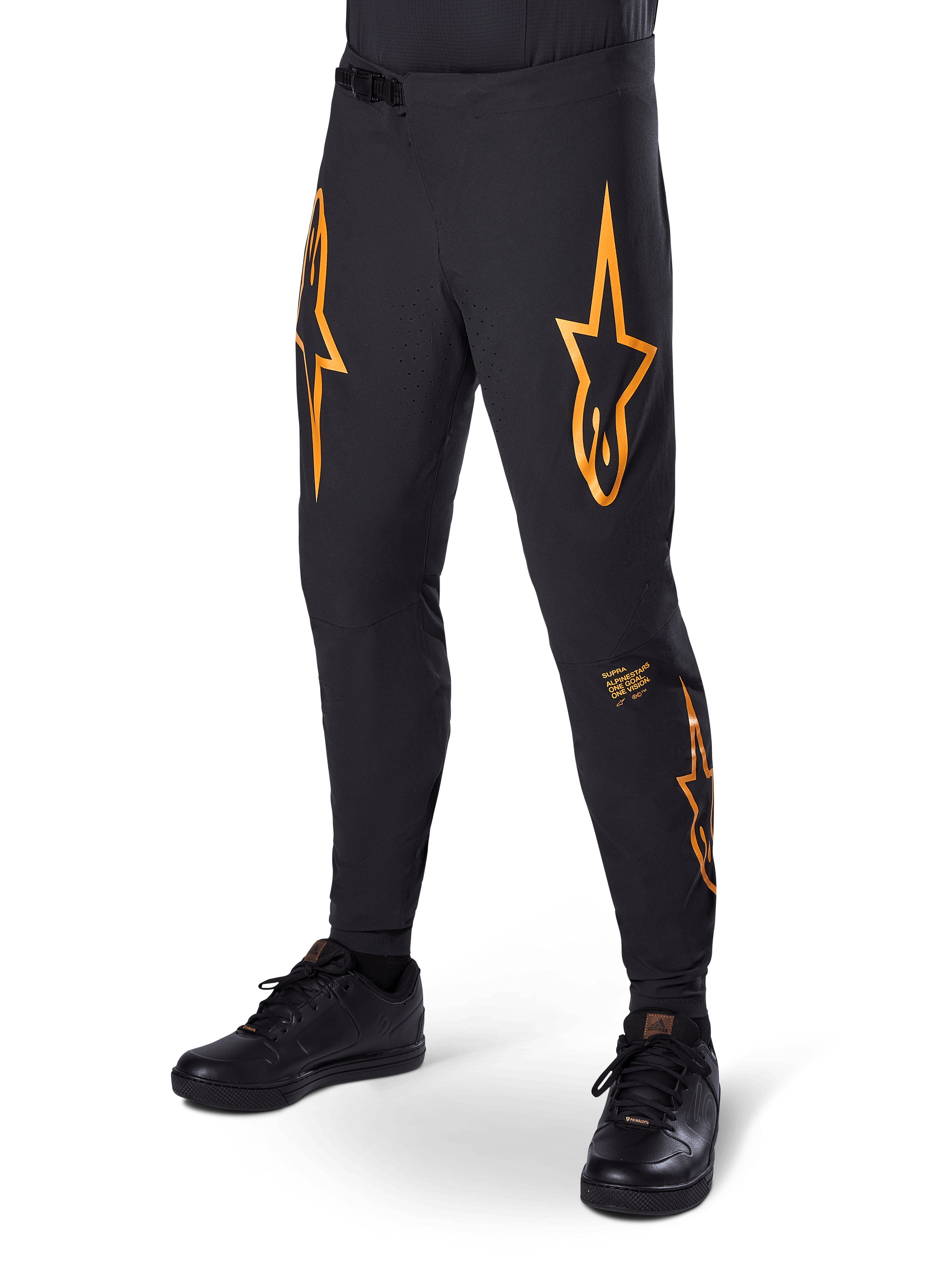 Alpinestars A-Supra Race Pants, czarne z pomarańczowymi grafikami w kształcie gwiazd, spodnie wyścigowe MTB z laserowo perforowaną wentylacją i zapięciem w pasie na zapadkę, dopasowany krój sportowy do kolarstwa terenowego
