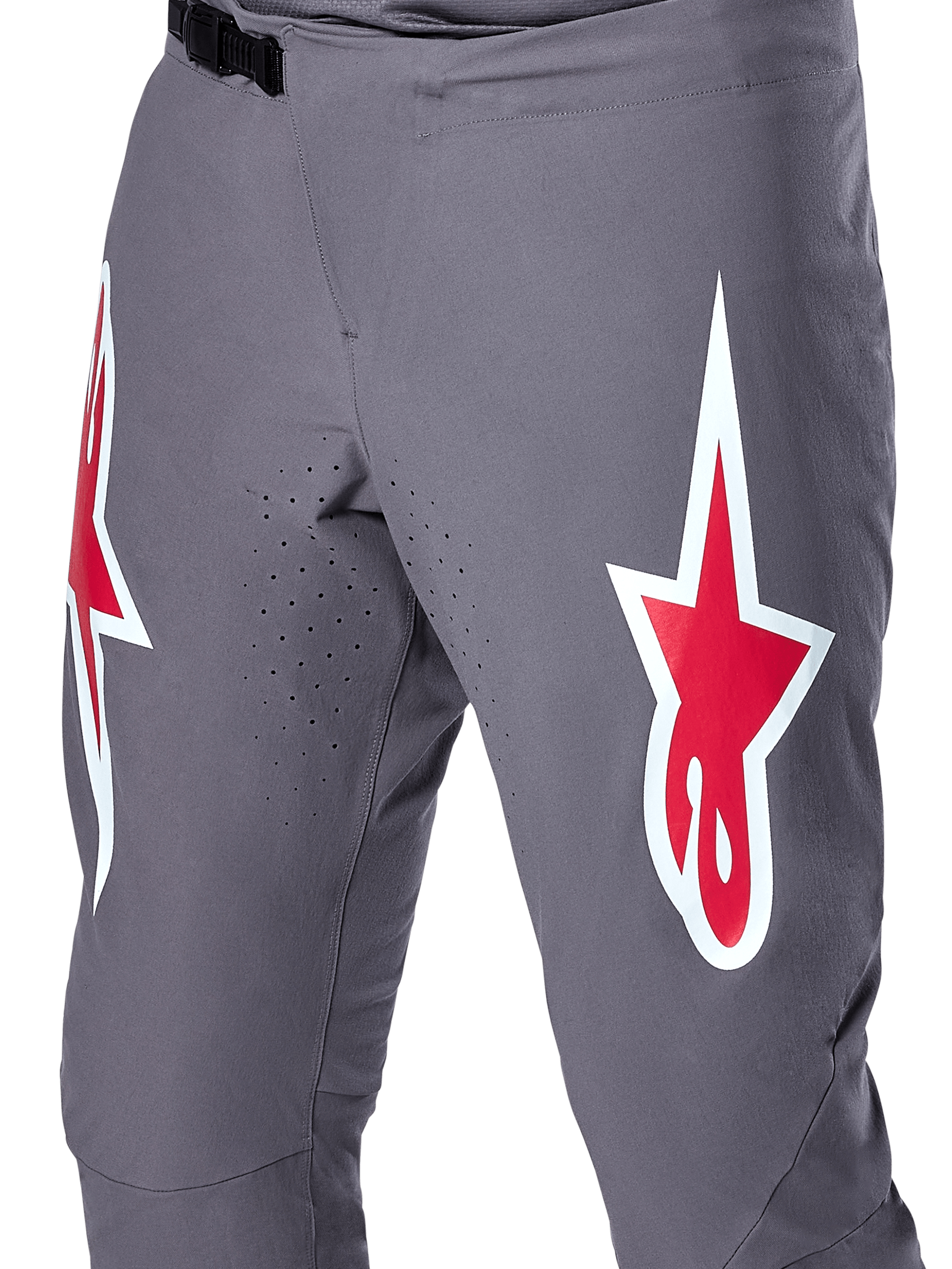 Alpinestars A-Supra Race Pants, spodnie rowerowe MTB, ciemnoszare z czerwonymi i białymi logo, zbliżenie na laserową perforację wentylacyjną na wewnętrznej stronie ud i czarne zapięcie zapadkowe w pasie.