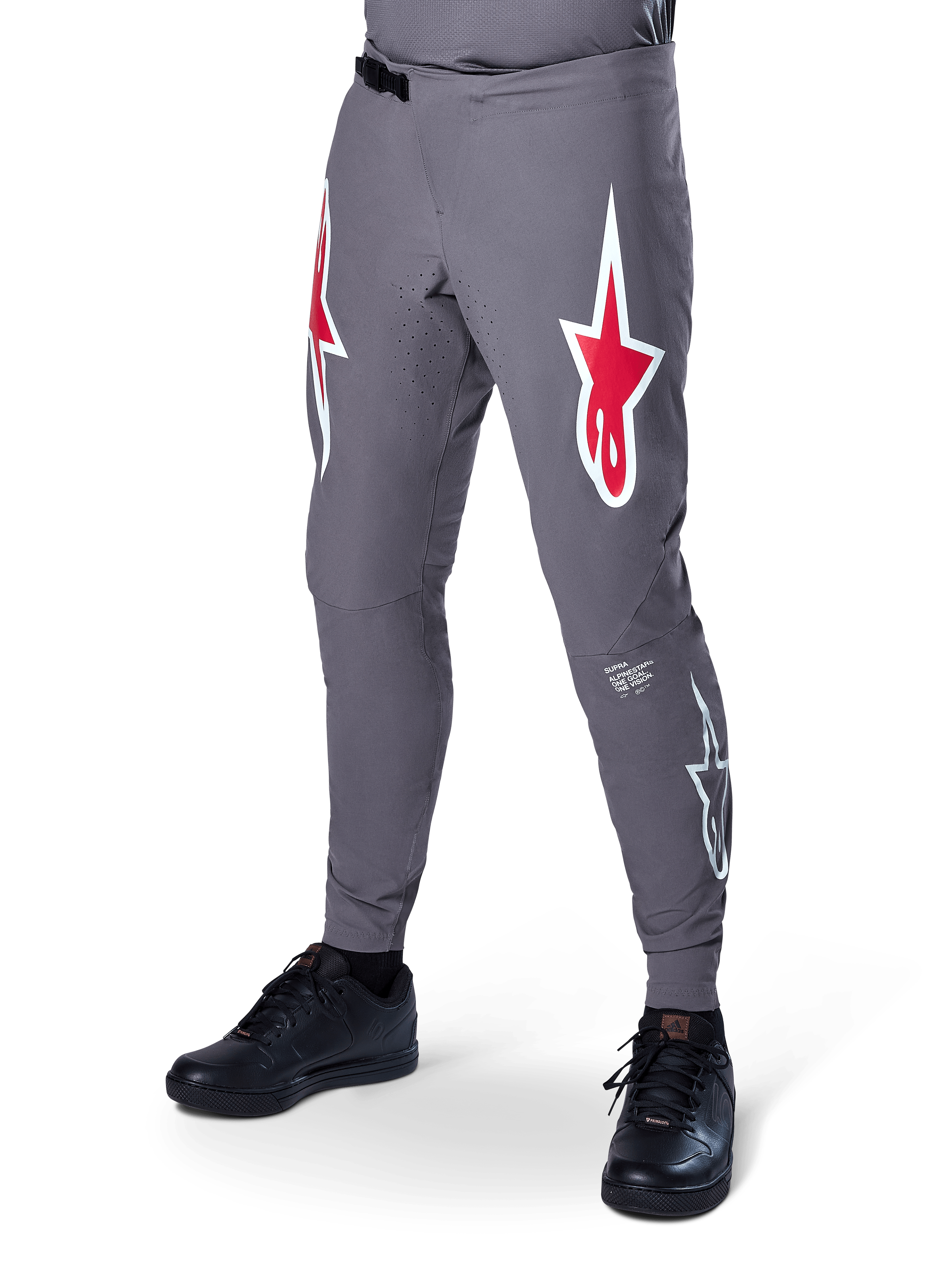 Alpinestars A-Supra Race Pants, ciemnoszare spodnie rowerowe MTB, z dużymi czerwono-białymi logotypami gwiazdy na udach, laserową perforacją dla wentylacji i zapięciem na zapadkę, sportowy krój do downhillu i enduro