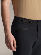 Alpinestars A-Dura Shorts, czarne spodenki MTB, zbliżenie na kieszeń zapinaną na zamek i regulowany boczny ściągacz, podwójne zapięcie na napy, wytrzymały materiał do kolarstwa górskiego