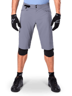 Alpinestars A-Dura Shorts, spodenki MTB, ciemnoszare, noszone z czarnymi rękawiczkami i ochraniaczami kolan Alpinestars, z podwójnym zapięciem na napy i kieszeniami na zamek z podszewką z siatki, wytrzymały materiał rozciągliwy w dwóch kierunkach do kolarstwa górskiego
